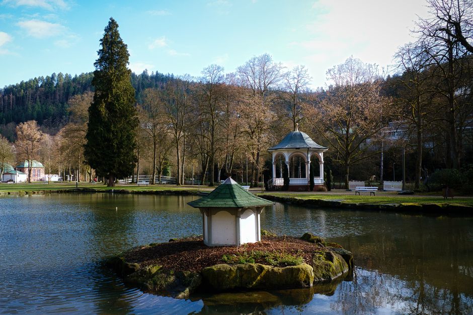 Luftbild des Kurpark Bad Aibling mit Wandelhalle, Seen und altem Baumbestand im Sonnenlicht